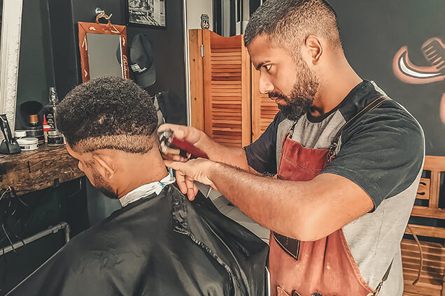 a barber is styling hair of a man in a salon